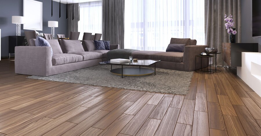 Modern living room with wood plank flooring, gray sofas, coffee table, and large windows with curtains