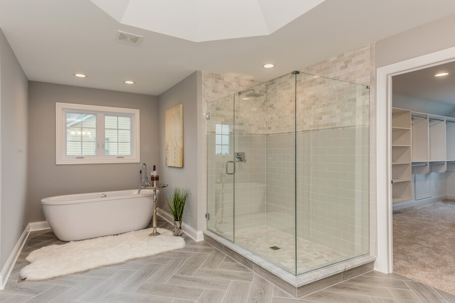 Modern bathroom with freestanding tub, glass walk-in shower, and adjoining walk-in closet